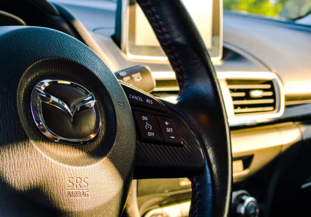 A close up shot of a steering wheels in a Mazda Rental car 